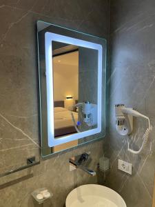 a bathroom with a mirror and a sink and a toilet at Adele Hotel Ksamil in Ksamil