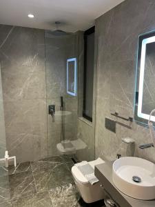 a bathroom with a shower and a toilet and a sink at Adele Hotel Ksamil in Ksamil