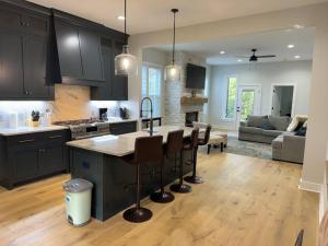 a kitchen with black cabinets and a table and chairs at Luxury Home 4B, 3B Sleeps 18 25min to Nashville in Greenlawn