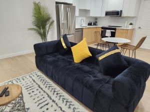 a blue couch with yellow pillows in a living room at Brand New Deluxe 2 Bedroom Suite with AC & Den in Calgary