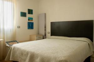 ein Schlafzimmer mit einem großen Bett mit großem Kopfteil in der Unterkunft 100 m from the beach with CABANA and JACUZZI included in Lignano Sabbiadoro
