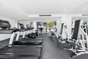 un gimnasio con varias cintas de correr y máquinas de cardio en Coastal Harbour Lights I Pool, Gym & prime Location, en Cairns