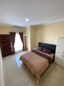 a bedroom with a large bed and a window at Merapi View Homestay in Ngaglik +11 photos