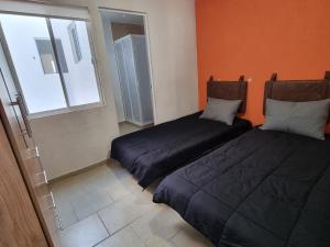 Un dormitorio con dos camas y una ventana en Hacienda San José, en Querétaro
