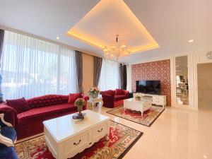 a living room with a red couch and a tv at Kirei Villa - Villa Mewah Dago in Bandung