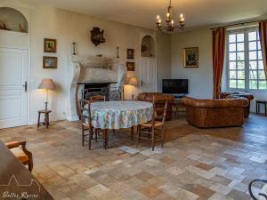 salon ze stołem i kominkiem w obiekcie Gîte de charme avec piscine chauffée et sauna, au cœur d'une propriété historique en Val de Loire - FR-1-381-128 w mieście Monnaie