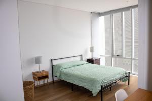 a bedroom with a bed with a green blanket on it at Condo con Alberca a un Paso del Estadio Azteca in Díaz +105 photos