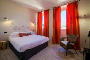 una camera da letto con un letto con tende rosse e una sedia di So&Leo Guest House a Genova