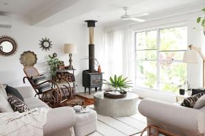 a living room with a couch and a stove at Buderim Rainforest Retreat - 10 mins to Mooloolaba in Buderim +15 photos