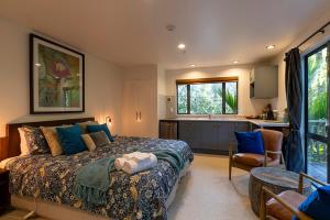 a bedroom with a large bed and a kitchen at Punakaiki Treehouse Limited in Punakaiki