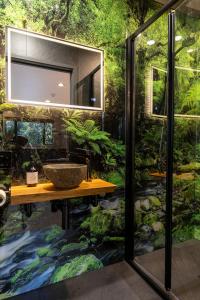 a bathroom with a sink and a forest at Punakaiki Treehouse Limited in Punakaiki