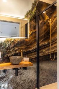 a bathroom with a stone sink on a wall at Punakaiki Treehouse Limited in Punakaiki