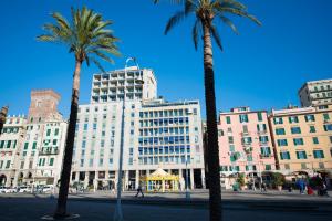 un gruppo di palme davanti a un edificio di So&Leo Guest House a Genova