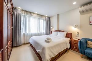a bedroom with a bed with a teddy bear on it at Woody House Saigon Center in Ho Chi Minh City +23 photos