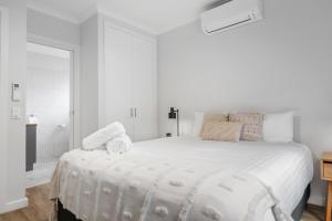 莫阿马Tasman Holiday Parks - Moama on the Murray的一间白色的卧室，有一张大床，上面放着毛巾