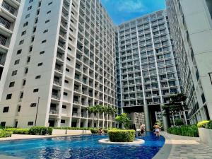a large building with a fountain in front of it at Staycation near Mall of Asia, Condotel with King Bed in Manila