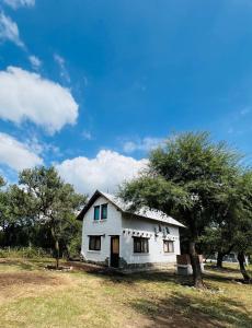 una casa blanca en un campo con árboles en Cabañas La Felicidad, en Merlo 10 fotos más