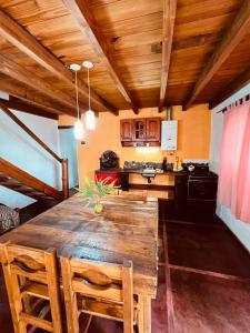 Una cocina con una mesa de madera en una habitación. en Cabañas La Felicidad, en Merlo
