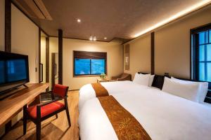 a hotel room with a large bed and a television at The Machiya Kamiumeya in Kyoto