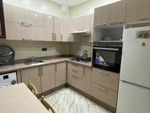a kitchen with wooden cabinets and a white refrigerator at Appartement agadir in Agadir