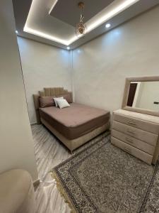 a bedroom with a bed and a dresser and a mirror at Appartement agadir in Agadir