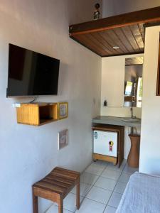 a living room with a flat screen tv on the wall at Pousada Algas Marinhas in Praia do Forte