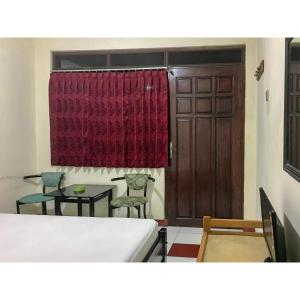a room with a door and two chairs and a table at Hotel Lie Mas Prigen Pasuruan Mitra RedDoorz in Pasuruan