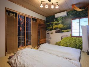 東京にあるComfort HASUNUMAのベッドと壁に絵が飾られた寝室