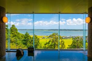 a large window in a building with a view of the water at KAMENOI HOTEL Itako in Itako