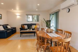 a living room with a table and a couch at Prime location at Mt Eden- Cozy Vibe 3BR Home in Auckland