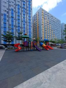 a playground in a park with tall buildings at SleepScape Staycation in Manila