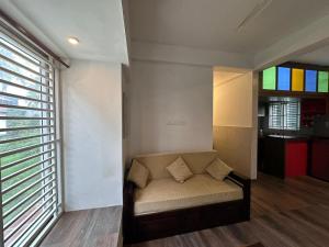 德里久尔DB Apartment Arimpur的带沙发和窗户的客厅 更多6张照片