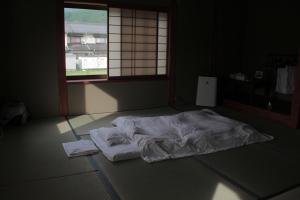 Rúm í herbergi á Guest House Kurukuru ゲストハウスくるくる