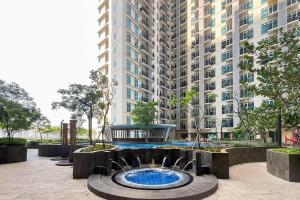 a fountain in front of a large building at RedLiving Apartemen Puri Orchard - Millenial Room Tower Orange in Jakarta