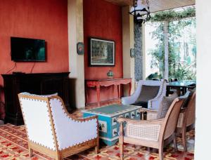 a room with chairs and a table and a fireplace at Kayu Arum Resort in Salatiga