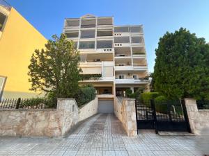 a tall apartment building with a driveway in front of it at VERA’S APARTMENT in Markopoulo