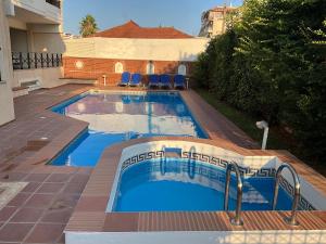 a swimming pool with blue water in a yard at VERA’S APARTMENT in Markopoulo