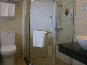 een badkamer met een douche, een toilet en een wastafel bij GreenTree Inn ShanDong JiNing JiaXiang County JianShe (S) Road Express Hotel in Jiaxiang