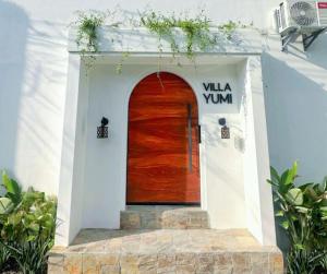 a brown wooden door in a white building at Villa Yumi in Lucena