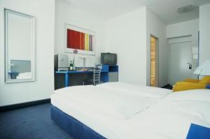 a hotel room with a bed and a television at Hotel Alt - Tegel in Berlin
