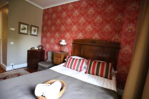 a bedroom with a bed and a red wall at Boutique Hotel Y&ouml;puu in Jyv&auml;skyl&auml;