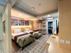 una camera d'albergo con due letti e un divano di Gracia Spa Resort Hotel a Ciater