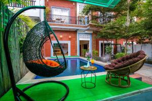 a swimming pool with two swings next to a house at Angkor Rithy Residencese in Phumi Ta Phul