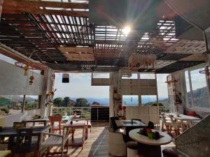 a restaurant with tables and chairs and a large window at Himalayan Musaafir Guest House & Restaurant in Dharamshala