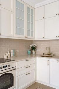 a white kitchen with white cabinets and a sink at great apartment in Madrid complex in Kirovo