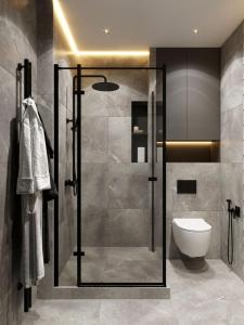 a bathroom with a glass shower with a toilet at great apartment in Madrid complex in Kirovo