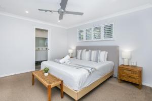 Un dormitorio blanco con una cama grande y una mesa. en Bliss And Harmony, en Gold Coast
