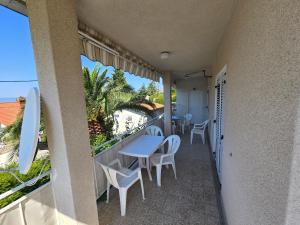 a balcony with tables and chairs and a view of the ocean at Apartment Stula in Omišalj