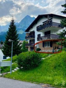 un bâtiment sur une colline avec un arbre à côté dans l'établissement Heimeliges Studio See und Berg, à Engelberg