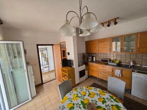 a kitchen with a table and chairs and a kitchen with a table and a kitchen at Apartment Stula in Omišalj